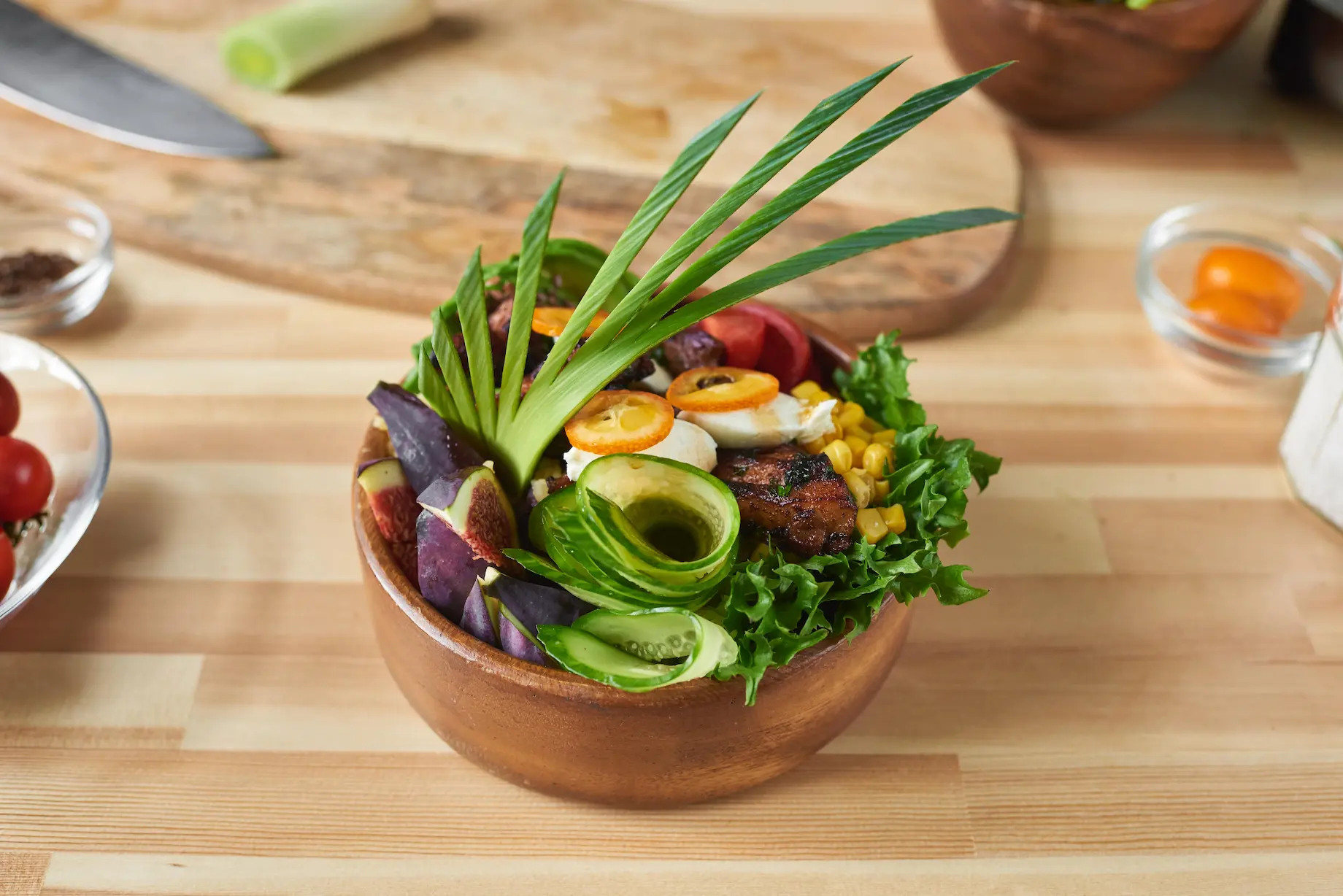 Dve surové hovädzie burgerové placky na rustikálnej drevenej doske so zrnkami soli a čierneho korenia, vedľa starožitný mlynček na korenie, na drevenom pozadí.