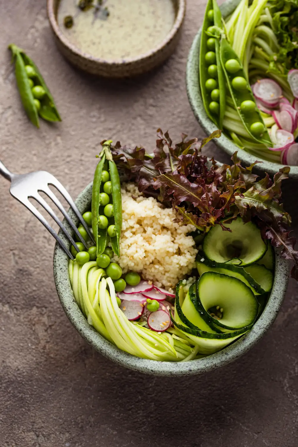 Burger so sezamovou žemľou, hovädzím mäsom, syrom, čerstvými paradajkami, cibuľou a rukolou, podávaný s jemne strúhanými hranolkami a menu v pozadí na drevenom stole.
